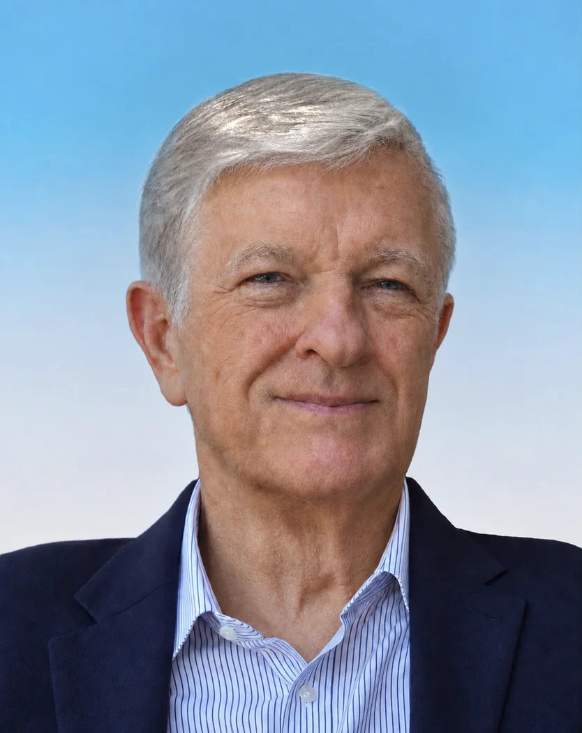Retrato de Roger L. Cowan, de saco azul oscuro, frente a un cielo celeste.